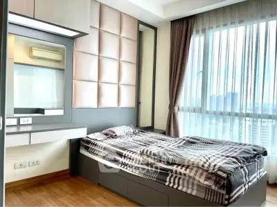Modern bedroom with stylish decor and large window offering city views