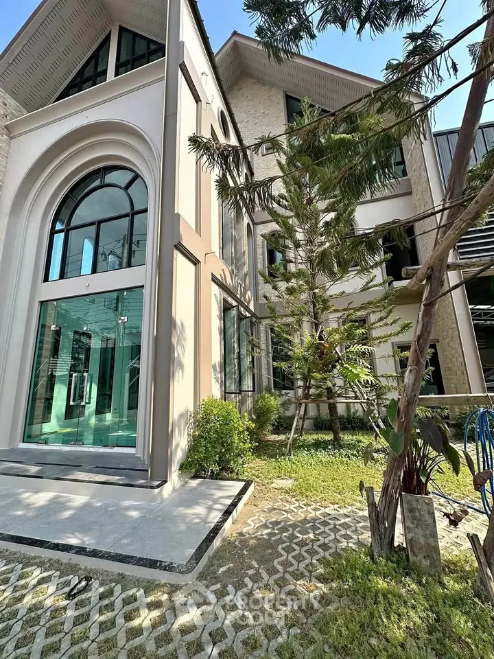 Stunning modern building exterior with large arched windows and lush landscaping.