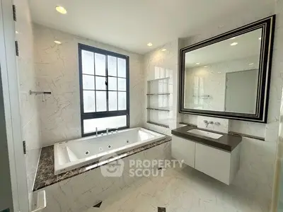 Luxurious bathroom with marble finishes and large soaking tub