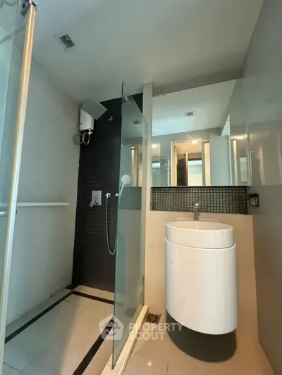 Modern bathroom with sleek shower and stylish sink in contemporary apartment.
