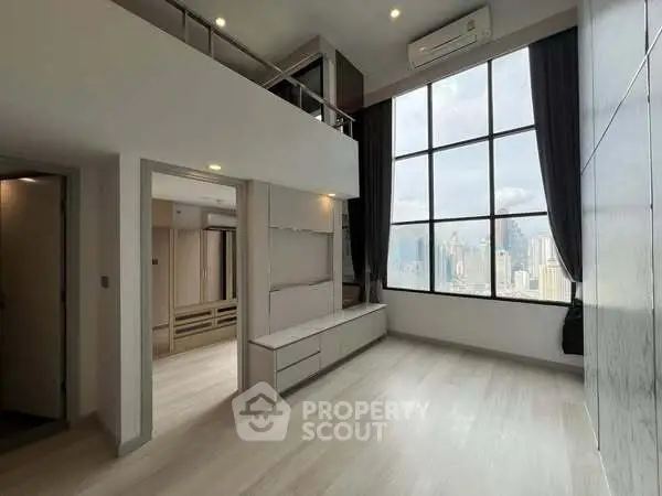 Spacious modern living room with high ceilings and city view, featuring large windows and sleek design.