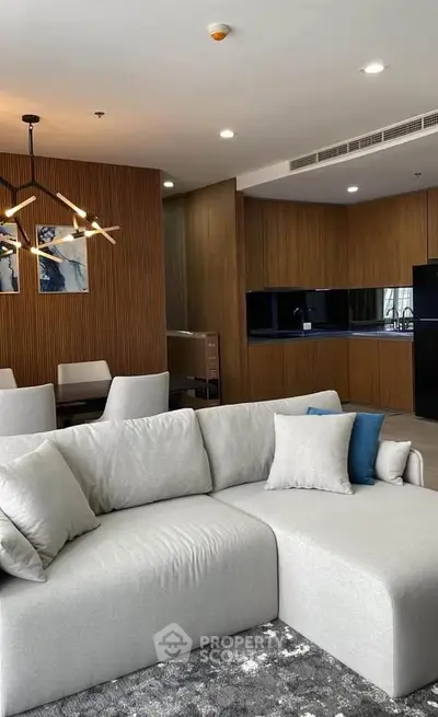 Modern living room with elegant sofa and open kitchen layout in luxury apartment.