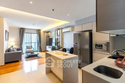 Modern open-layout kitchen and living room with sleek appliances and stylish decor.