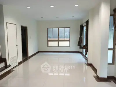 Spacious empty living room with large windows and glossy tile flooring