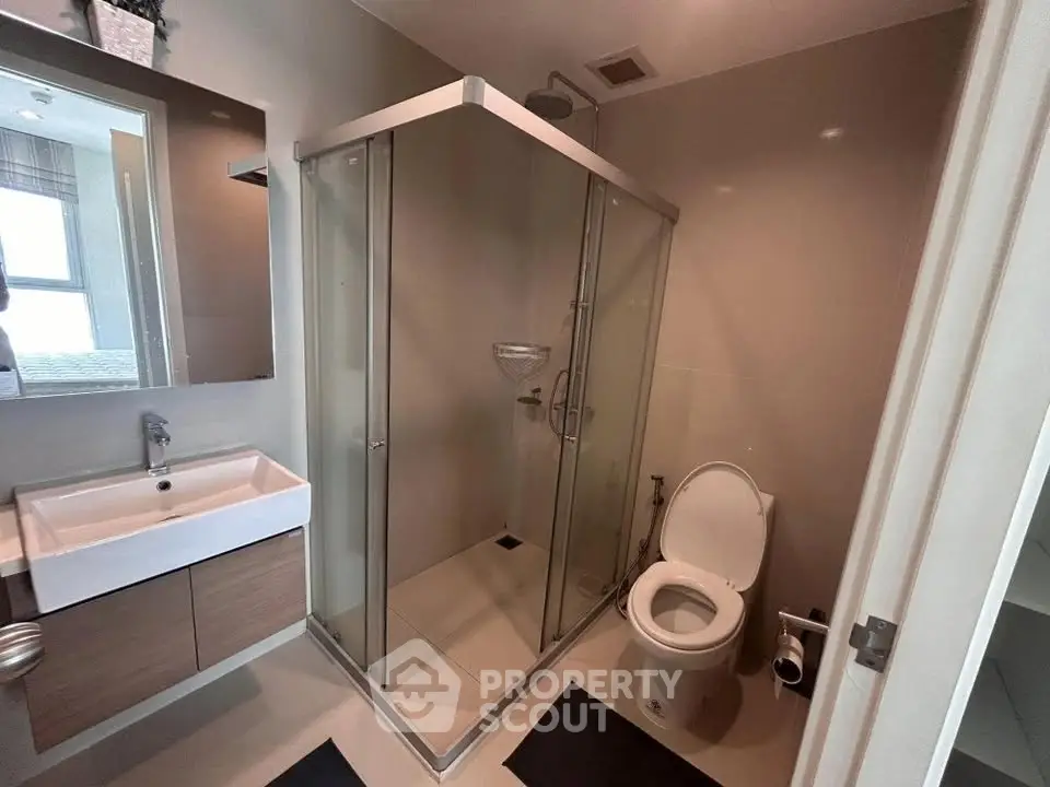 Modern bathroom with glass shower enclosure and sleek fixtures