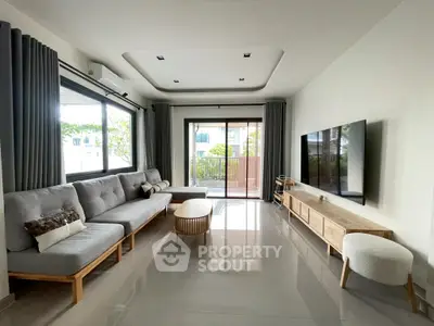 Spacious modern living room with large windows and sleek furniture