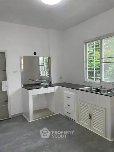 Modern kitchen with sleek countertops and ample natural light, perfect for culinary enthusiasts.
