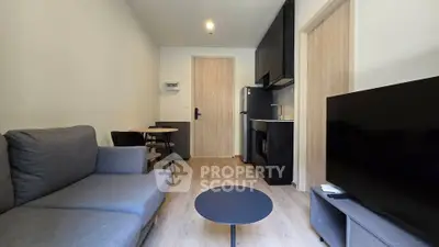 Modern living room with sleek furniture and open kitchen layout in a stylish apartment.