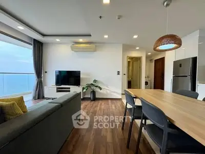Modern living room with ocean view, sleek furniture, and open layout.