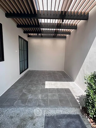Modern covered patio with sleek tile flooring and stylish pergola, perfect for outdoor relaxation.