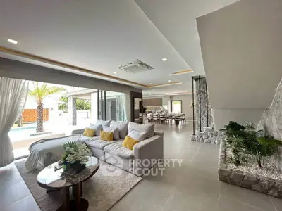 Luxurious open-plan living room with modern decor and pool view