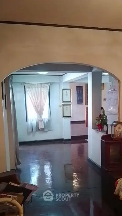 Charming interior with polished wooden floors and elegant archway, perfect for cozy living.