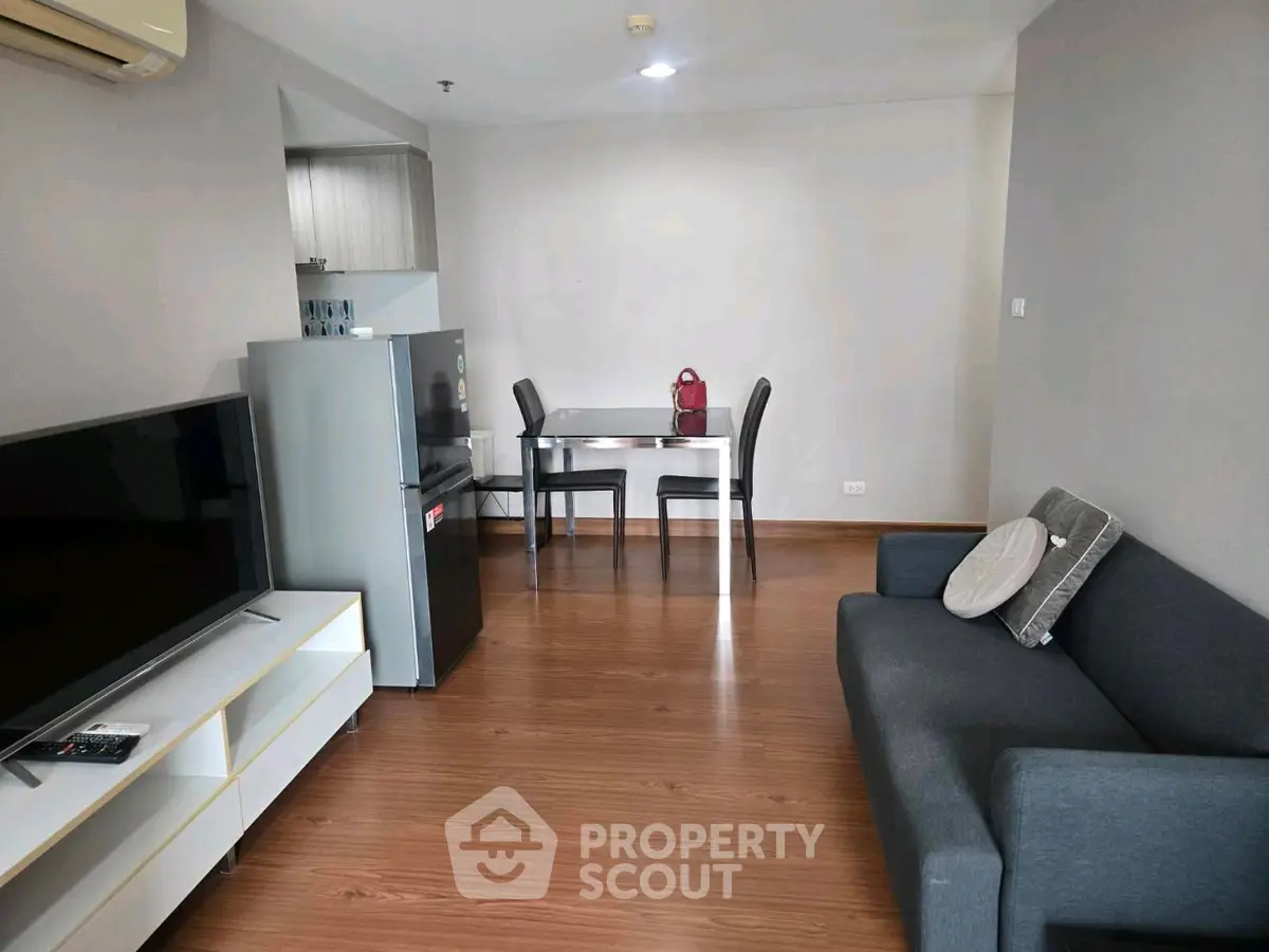 Modern living room with sleek furniture and open kitchen layout, perfect for urban living.