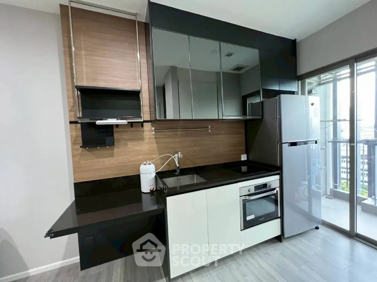 Modern kitchen with sleek design, featuring built-in oven and large fridge, perfect for contemporary living.