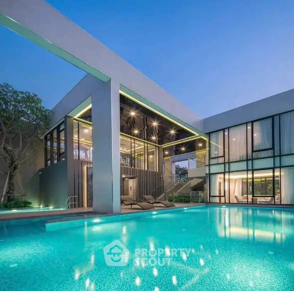 Luxurious modern villa with stunning pool and glass facade at dusk