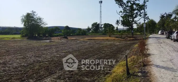 Expansive plot of land with potential for development, featuring clear skies and surrounding greenery.