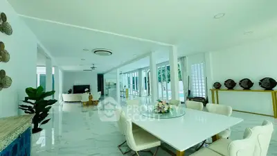 Luxurious open-plan living and dining area with elegant decor and large windows offering natural light.