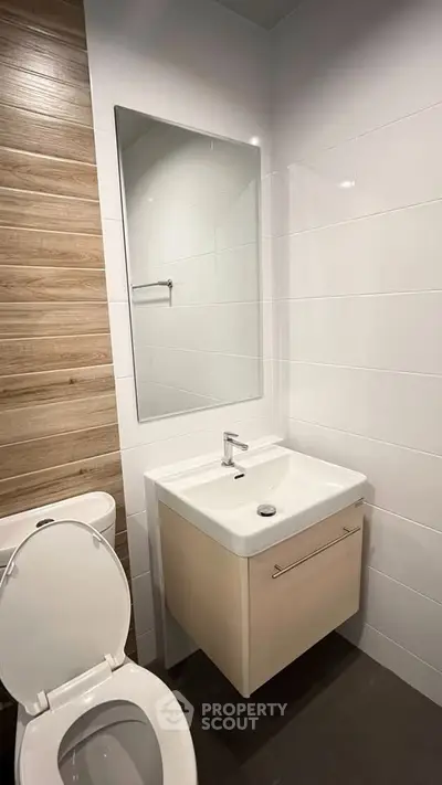 Modern bathroom with sleek fixtures and wooden accent wall
