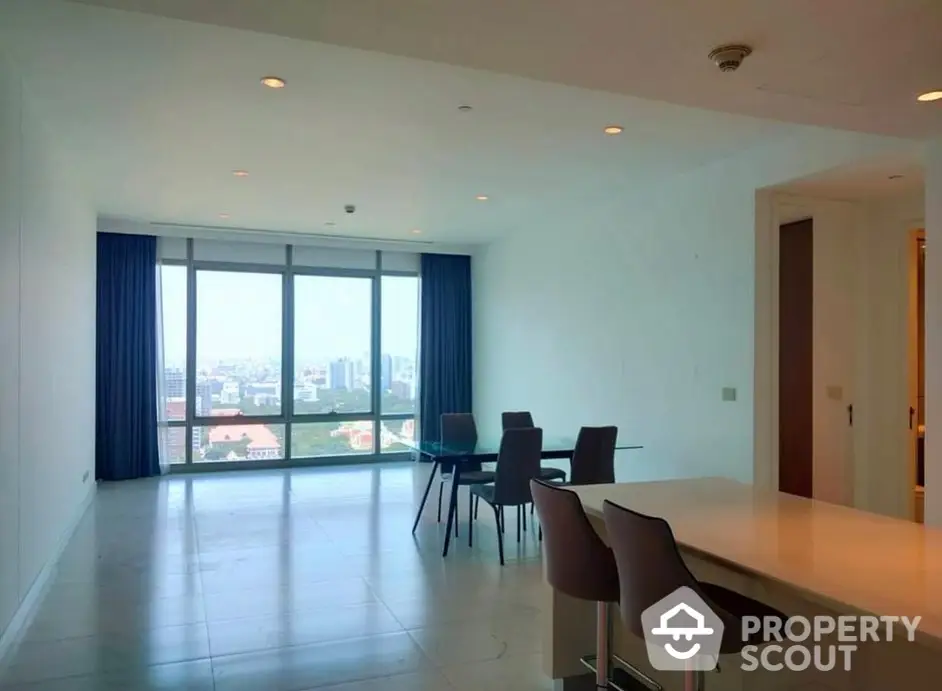 Spacious high-rise apartment with gleaming floors, modern dining area, and expansive city views through large windows, perfect for urban living.