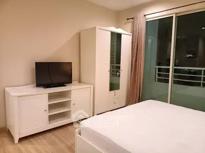 Modern bedroom with balcony access and sleek white furniture.