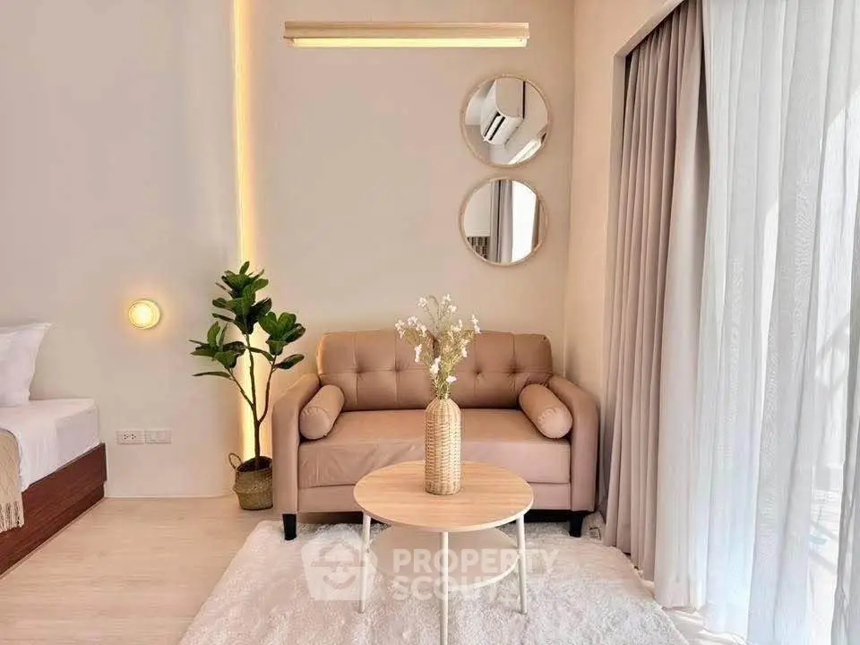 Chic living room with cozy sofa, stylish decor, and natural light from large window.