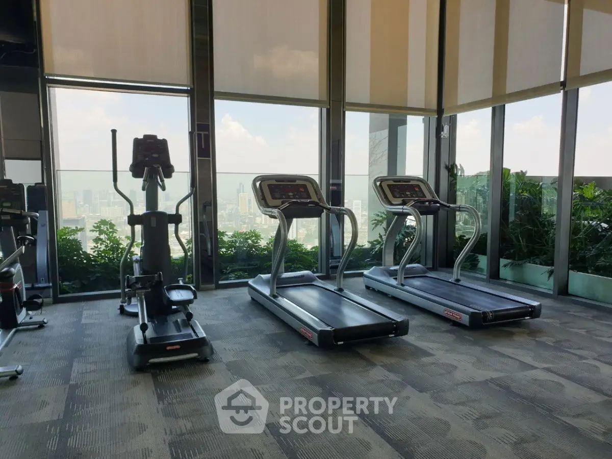 Modern gym with treadmills and elliptical overlooking city skyline