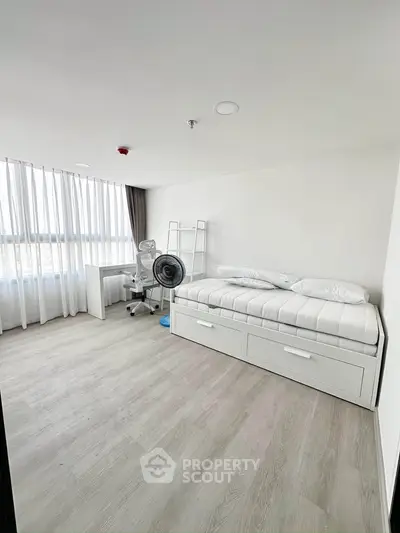 Modern minimalist bedroom with sleek white furniture and large window for natural light.