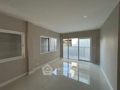Spacious empty room with large windows and balcony access, perfect for customization.