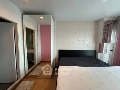 Spacious bedroom with modern decor and mirrored wardrobe in a stylish apartment.