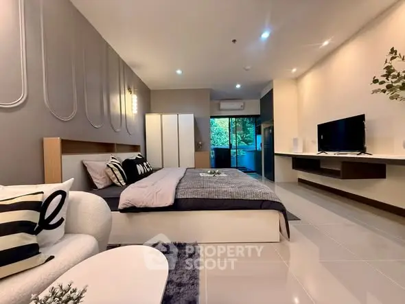 Spacious modern bedroom with elegant decor and large windows