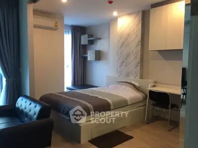 Modern studio apartment with cozy bed, stylish decor, and natural light.