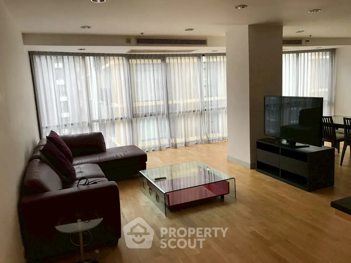 Spacious modern living room with large windows and sleek furniture