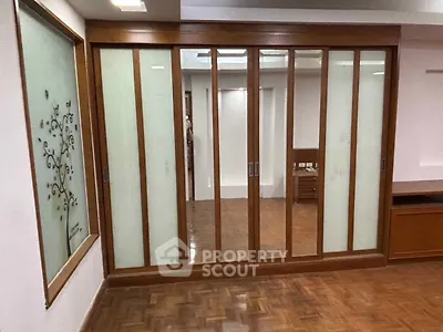 Spacious room with elegant wooden sliding doors and parquet flooring, perfect for modern living.