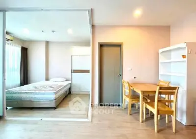 Modern studio apartment with cozy bedroom and dining area, featuring wooden furniture and natural light.