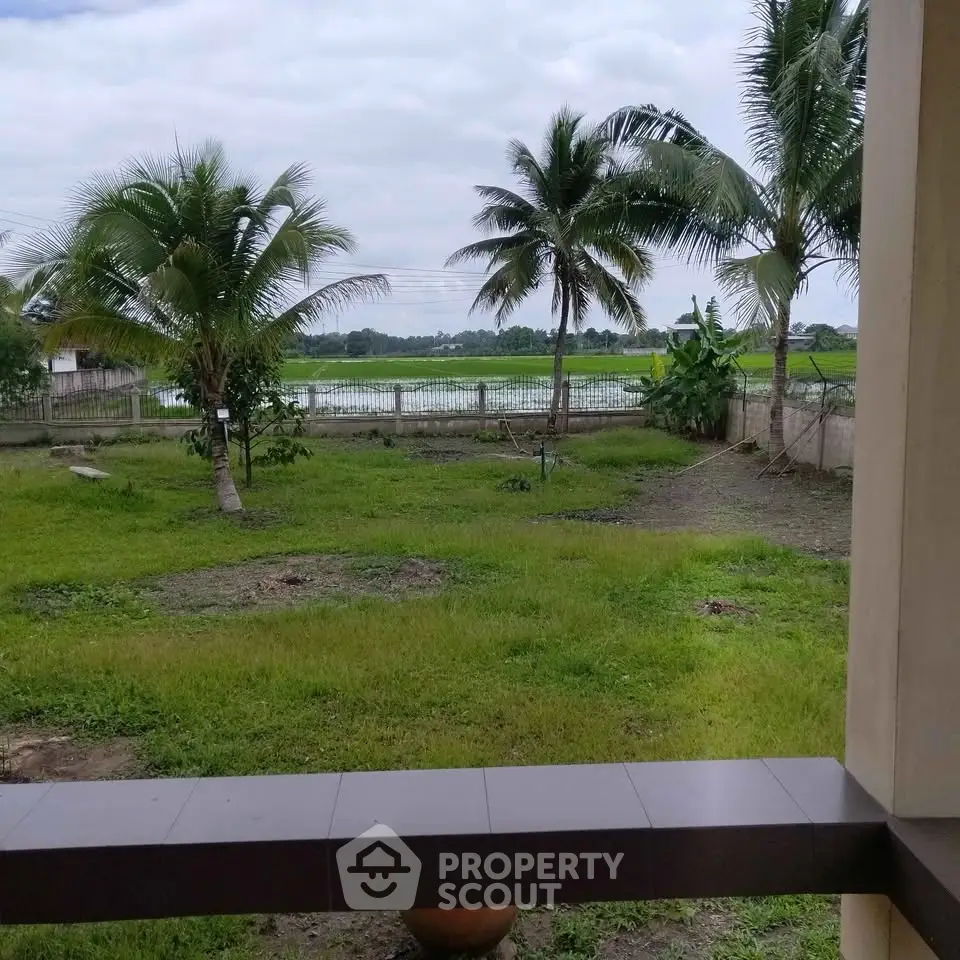 Scenic view of lush garden with palm trees and serene water body, perfect for tranquil living.