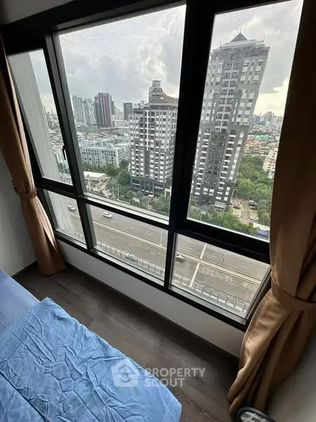 Stunning high-rise bedroom view with floor-to-ceiling windows overlooking cityscape.