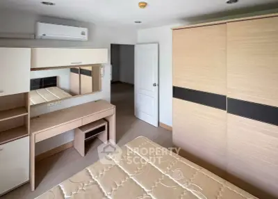 Spacious bedroom with modern furniture and ample storage space