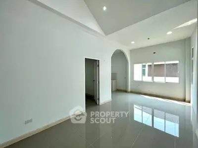 Spacious modern living room with glossy tiled floors and large windows for natural light.