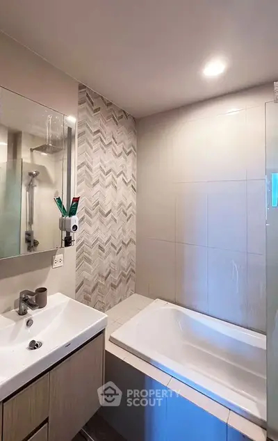 Modern bathroom with stylish tiles and built-in bathtub