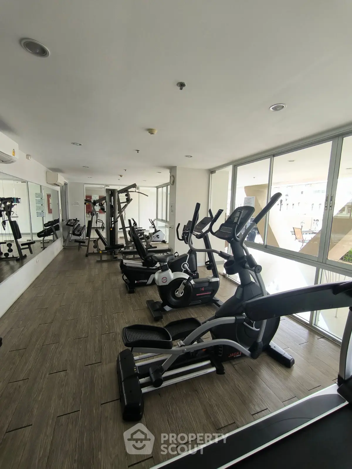 Modern gym with state-of-the-art fitness equipment and large windows for natural light.
