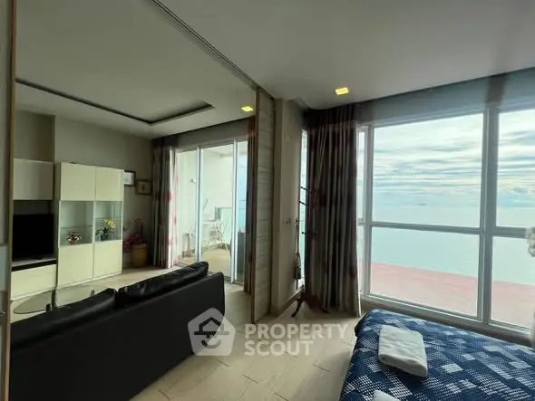 Stunning ocean view from modern living room with balcony access in luxury apartment.