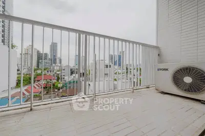 Spacious balcony with city view and air conditioning unit, perfect for relaxation.