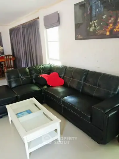 Spacious living room with stylish black leather sofa and modern decor