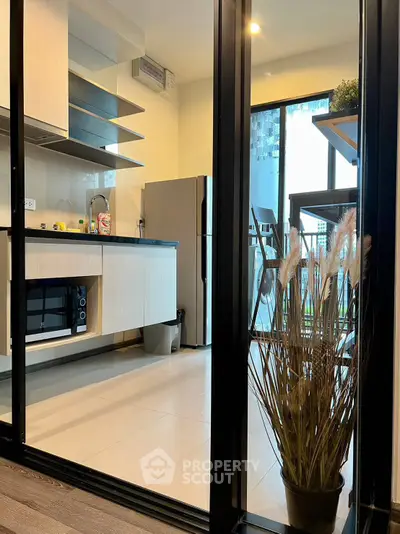 Modern kitchen with sleek cabinetry and stainless steel appliances in a stylish apartment.
