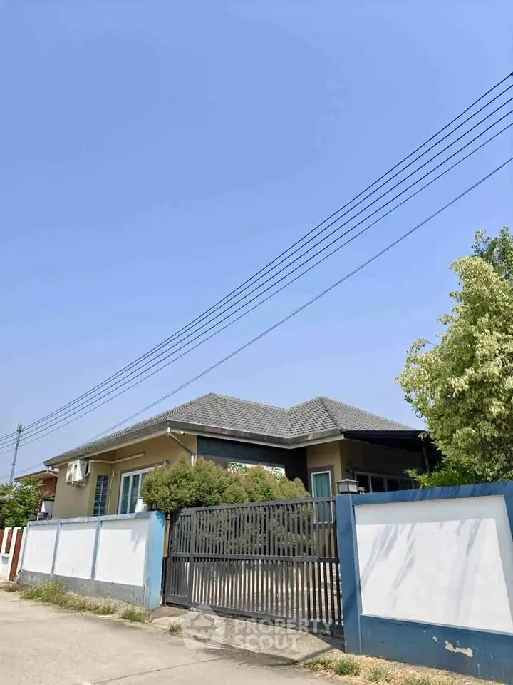 Charming single-story home with gated entrance and lush greenery, perfect for serene living.