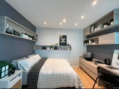 Modern bedroom with stylish decor and ample storage, featuring a cozy bed and sleek shelving.