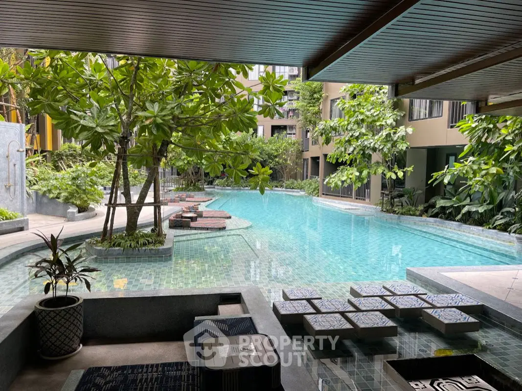 Luxurious poolside view with lush greenery and modern architecture in a serene residential complex.