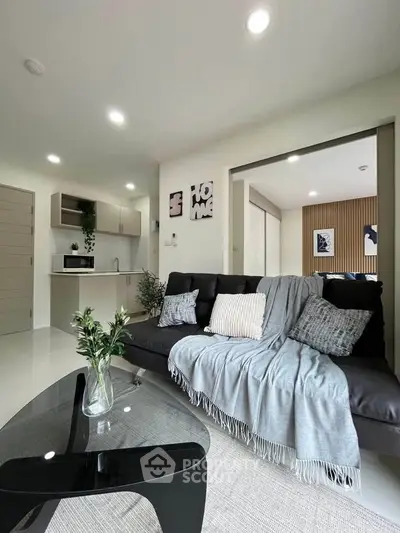 Modern living room with sleek sofa and open kitchen layout