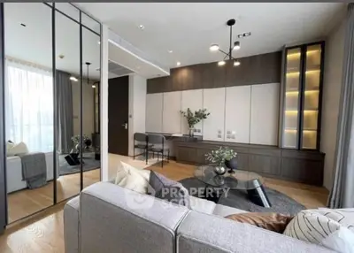 Modern living room with sleek design and elegant furnishings, featuring a large mirror and stylish lighting.