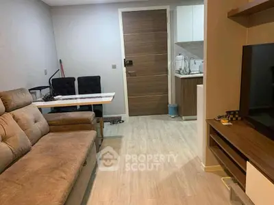 Modern living room with cozy sofa and open kitchen layout in stylish apartment.